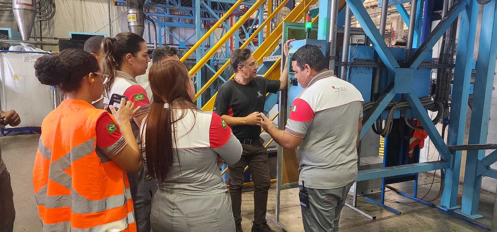 Equipe em treinamento junto à máquina